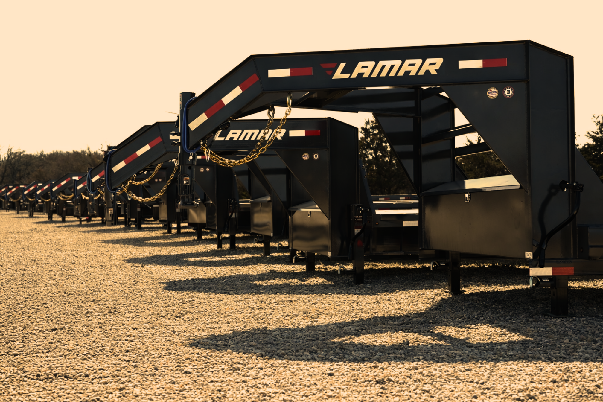 lamar trailers lined up in a gravel parking lot